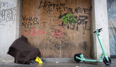 Ein obdachloser Mann hat sich an einem Haus zum Schlafen hingelegt. In Halle sollen für Bedürftige Kälterucksäcke gepackt werden (Symbolbild).