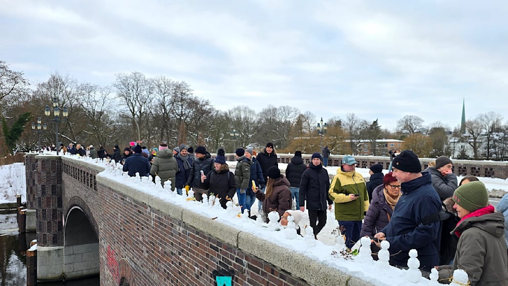 Ein Schneemann reiht sich auf der Krugkoppelbrücke an den anderen an