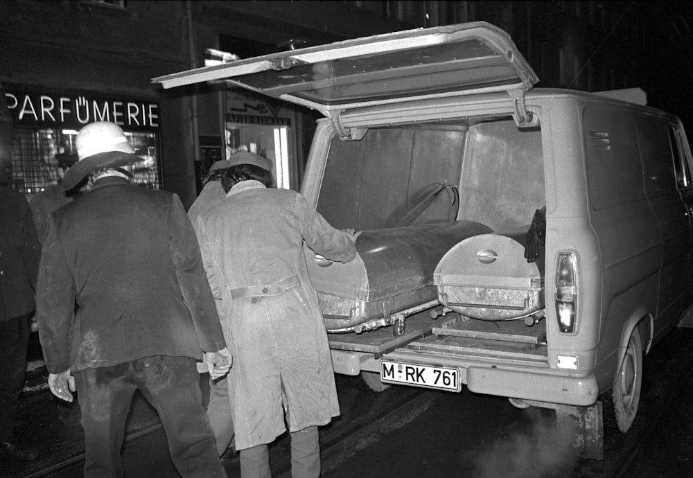 Der Brandanschlag forderte sieben Todesopfer, die in Zinksärgen abtransportiert wurden.