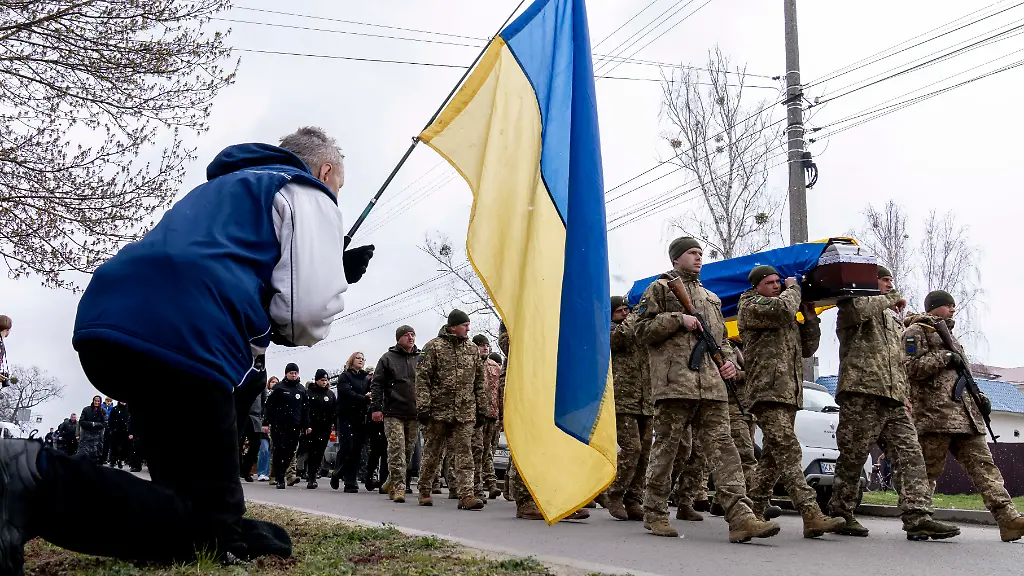 April-11-2025-Slavuta-Khmelnytskyi-Oblast-Ukraine-People-kneel-in-the-town-of-Slavuta-paying-their-respect-as-the-coffin-of-fallen-service-member-of-the-Ukrainian-Armed-Forces-Oleksandr-Oleksandrovych-Samoilovych-is-carried-to-the-local-church-Born-on-September-17-2006-Samoilovych-was-only-18-years-old-when-he-was-killed-in-the-Pokrovsk-region-on-April-5-2025