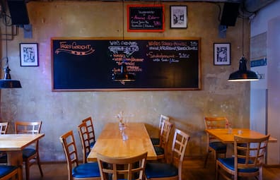 Gedimmtes Licht, Holzmöbel und Betoncharme – das Alte Wettbüro ist für sein Ambiente bekannt.