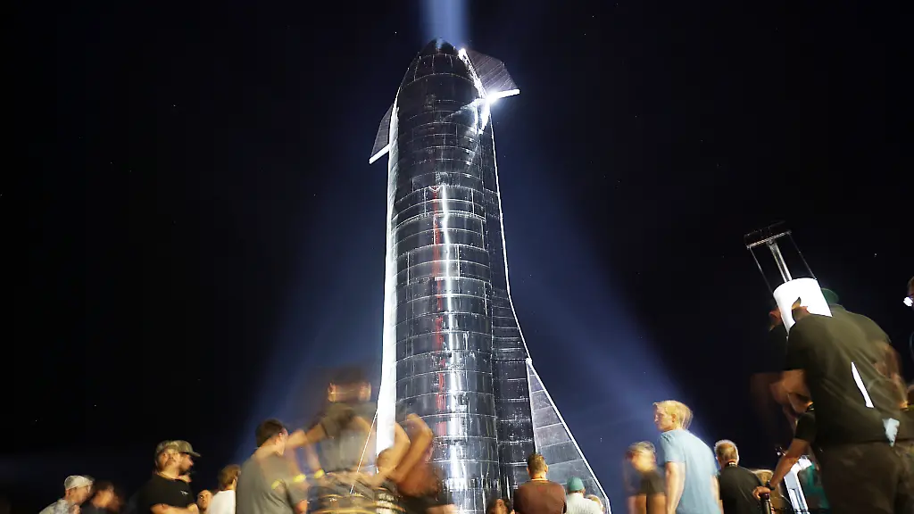 Besucher-tummeln-sich-vor-dem-Raumschiff-Starship-Mk1-am-28-September-2019-in-Texas-Mit-dem-Raumschiff-Starship-und-der-Rakete-Super-Heavy-hat-SpaceX-Chef-Musk-die-geplante-naechste-Generation-seiner-Raumfahrzeuge-vorgestellt-Das-komplett-wiederverwendbare-Transportsystem-koenne-einmal-mit-Menschen-und-Fracht-zum-Mars-zum-Mond-oder-zu-jedem-anderen-Ort-in-unserem-Sonnensystem-fliegen-so-Musk