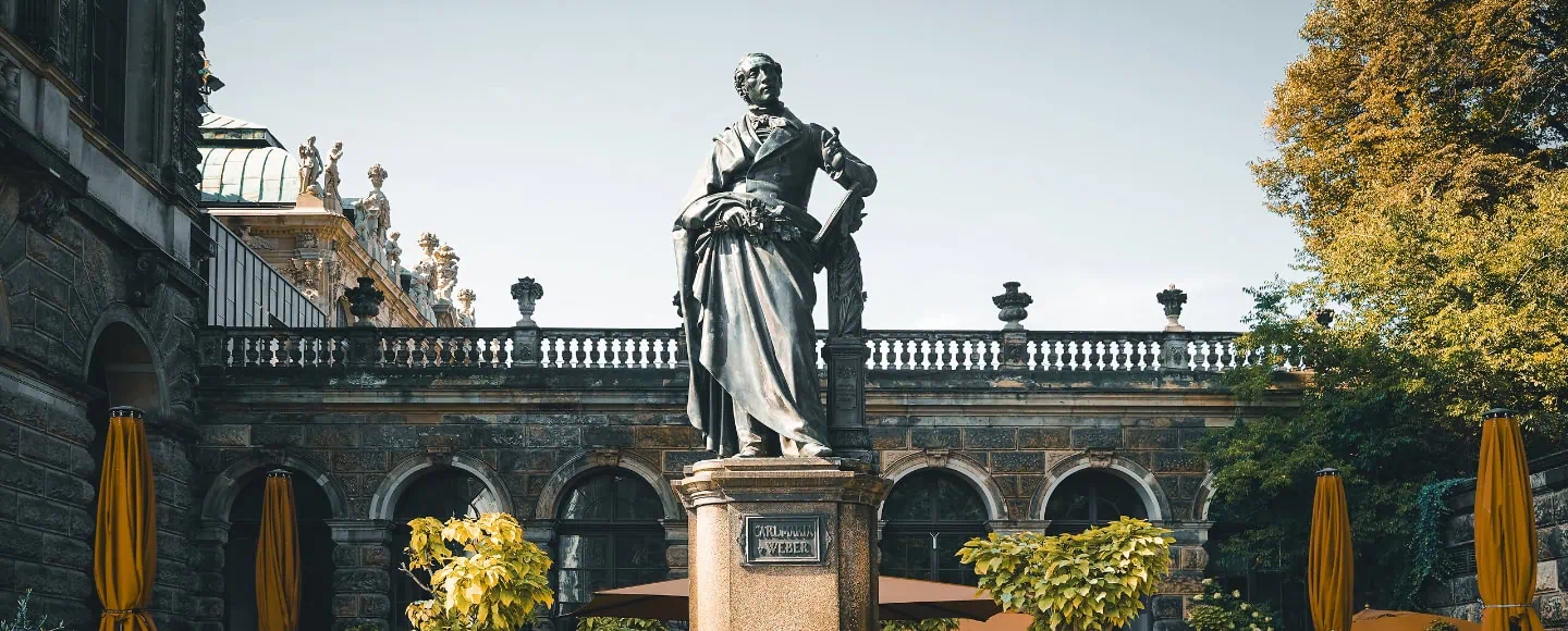 Statue von Car Maria von Weber auf einem Marmorsockel am Theaterplatz in Dresden.