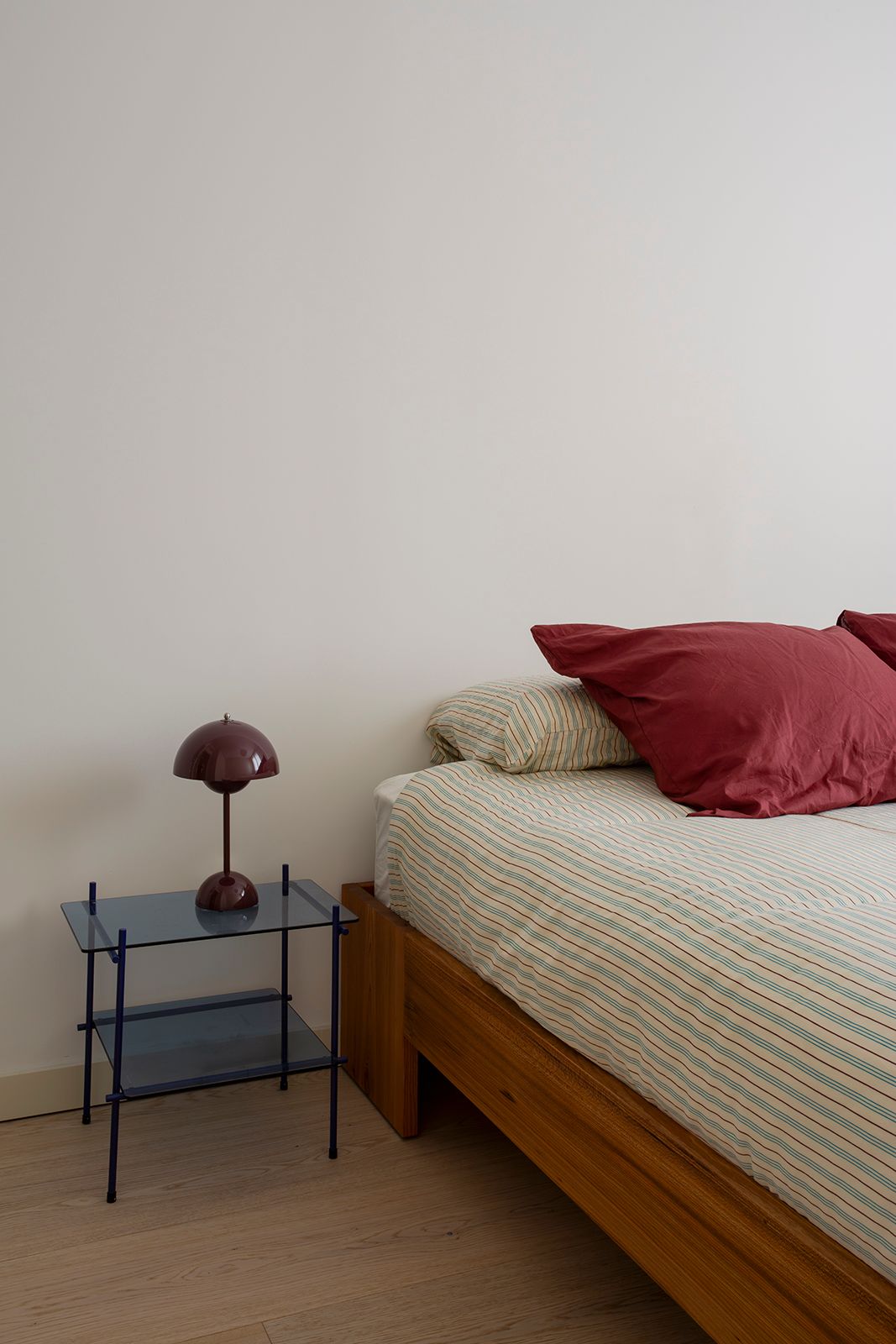 Renovierung in Madrid Schlafzimmer Bett ohne Kopfteil gestreifte Bettwäsche