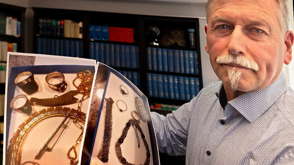 Der-bei-dem-Sparkassenraub-in-Gelsenkirchen-geschaedigte-Joachim-Alfred-Wagner-zeigt-Fotos-von-Wertgegenstaenden-in-der-Kanzlei-des-Rechtsanwalts-Daniel-Kuhlmann-Die-Kanzlei-Kuhlmann-vertritt-und-beraet-zahlreiche-von-dem-Raub-betroffene-Sparkassenkunden