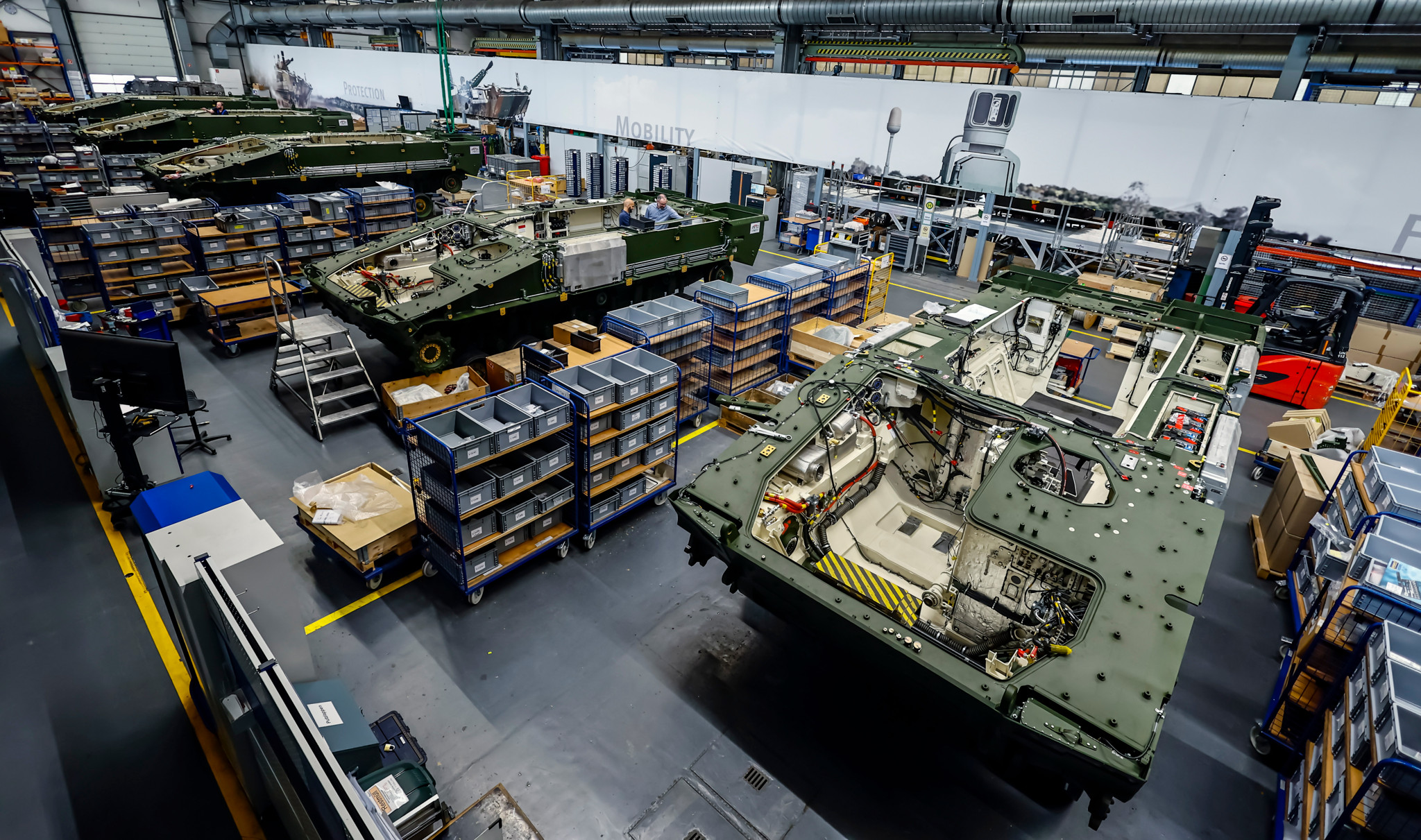 Produktion von Lynx-Schützenpanzern bei Rheinmetall AG in Unterlüss, Deutschland, 06. Juni 2023, mit mehreren gepanzerten Fahrzeugen in einer Werkhalle.