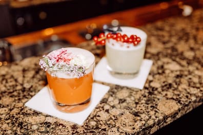 Üppige Deko, veganer Eiweißschaum: Die alkoholfreien Drinks Apero Sour (links) und Mezcal Sour kosten im „Oscar's“ 12,50 Euro. 