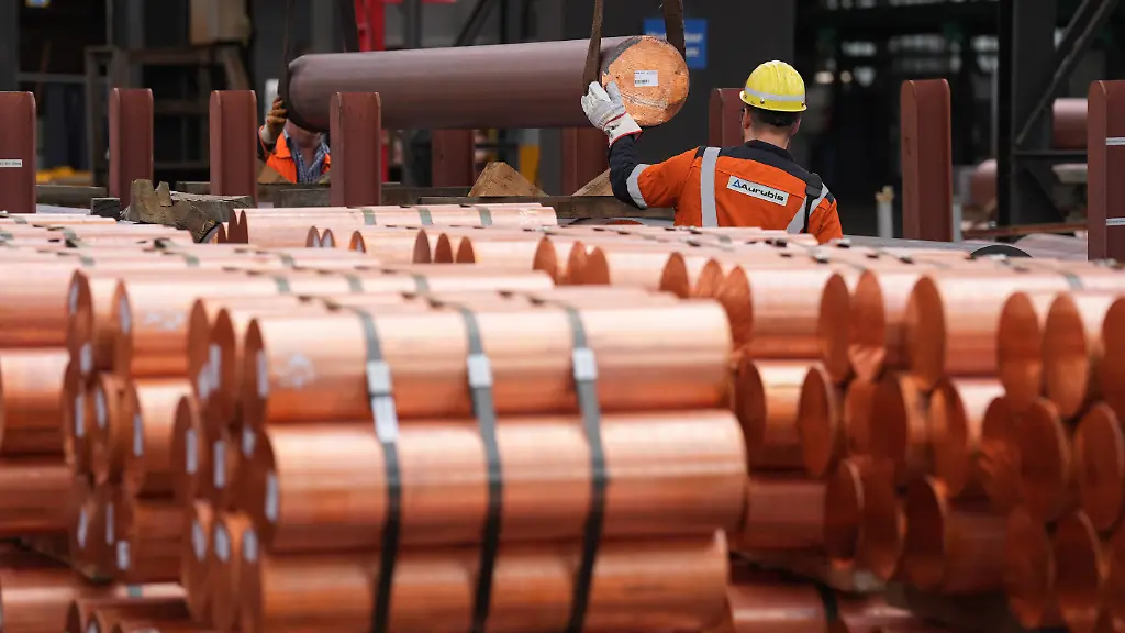 Mitarbeiter-begleiten-das-Kranen-von-Kupferbarren-in-der-Strangussanlage-bei-der-Aurubis-AG-Die-Aurubis-AG-ist-ein-boersennotierter-Kupferproduzent-sowie-Kupferwiederverwerter-mit-Sitz-in-Hamburg