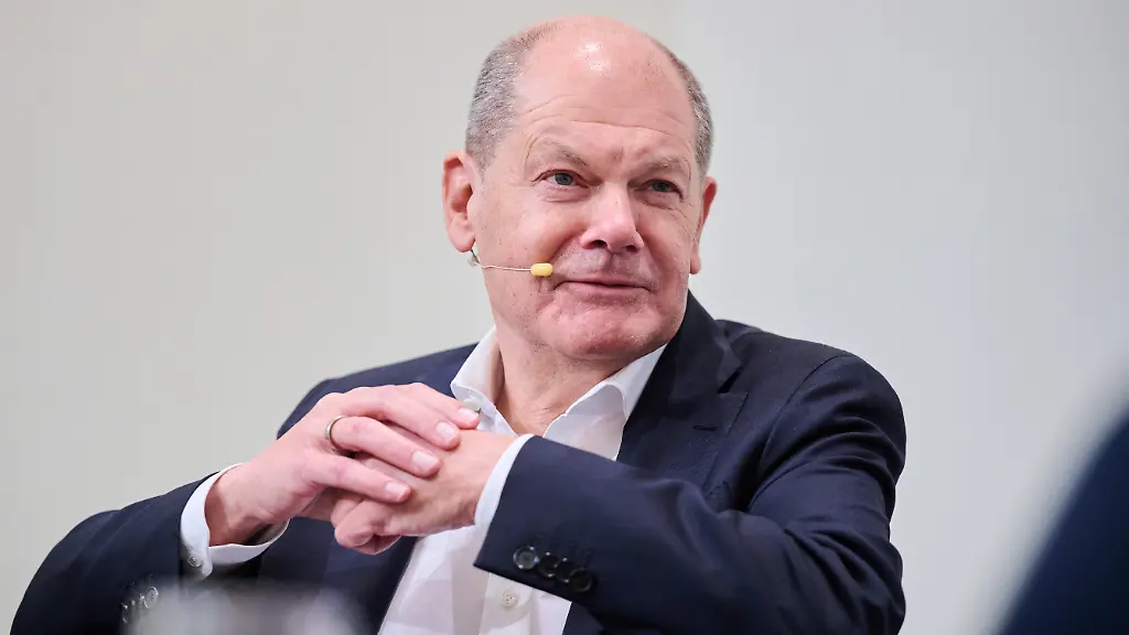 Olaf-Scholz-ehemaliger-Bundeskanzler-spricht-in-der-Landesvertretung-Hamburg-waehrend-er-zusammen-mit-dem-Autor-des-Buches-Das-Versagen-und-dem-ehemaligen-Botschafter-Ischinger-auf-der-Buehne-sitzt-In-dem-Buch-des-Ehepaars-Mascolo-und-Gloger-wird-eine-kritische-Bilanz-der-deutschen-Russlandpolitik-gezogen