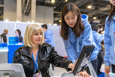 A visitor at the Kolmar Korea booth listens to an explanation of the company's AI-based technology during CES 2026.