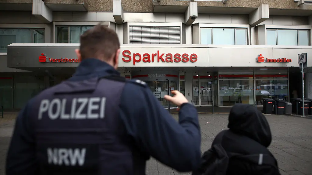 Police-talks-to-people-after-thieves-used-the-quiet-Christmas-period-to-drill-their-way-into-the-vault-of-a-branch-of-Sparkasse-bank-and-make-off-with-money-and-valuables-from-customers-safe-deposit-boxes-in-Gelsenkirchen-Germany-December-31-2025