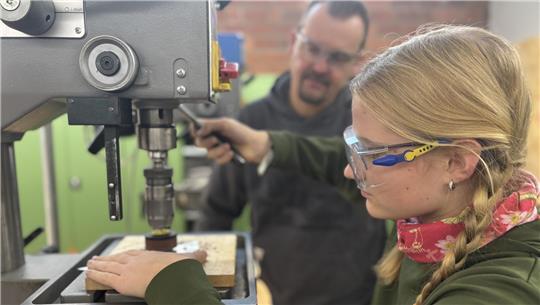 Victoria ist konzentriert bei der Arbeit. Sie schneidet eine Metallplatte für ihre Designer-Uhr zurecht.