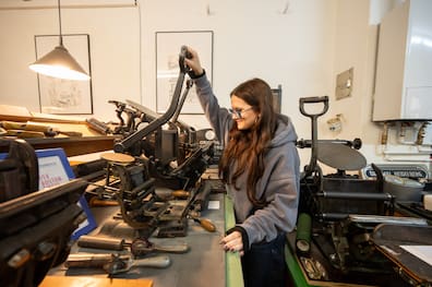 Hands on: Die 18-jährige Solea probiert eine der Boston-Tiegel-Druckmaschinen aus.