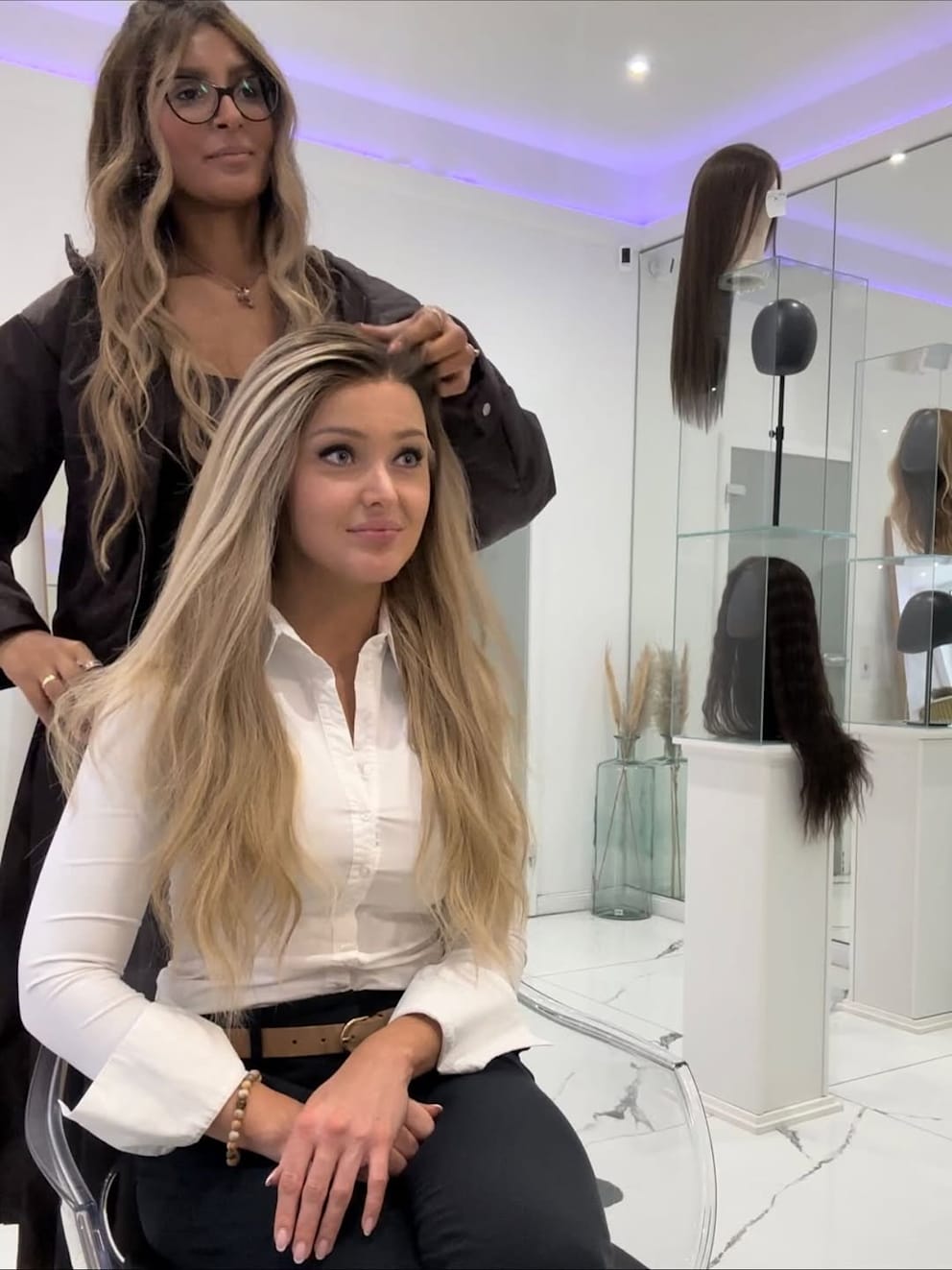 Hier, im Oktober 2025, ließ sich Patrice bei einem Termin verschiedene Perücken zeigen und probiert einige davon aus