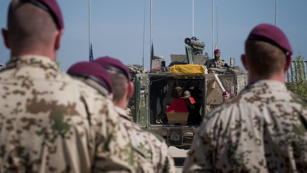 Deutsche Soldaten ehren drei gefallene Bundeswehrangehörige aus dem Bundesland Niedersachsen bei einer Zeremonie in einem Militärlager nahe Kunduz in Nordafghanistan am 4. April 2010. Anwesend ist auch Entwicklungsminister Dirk Niebel