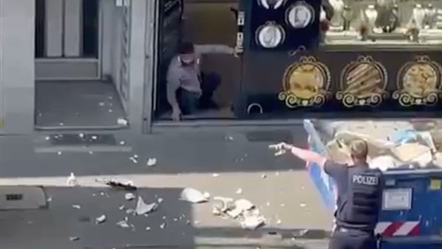 Ein Räuber gibt auf, wirft die Waffe auf den Gehweg