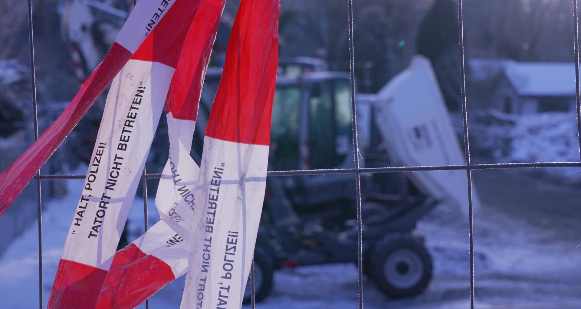 Ein Absperrband "Halt Polizei! Tatort nicht betreten!" hängt an einem Zaun um das Heizkraftwerk Lichterfelde.