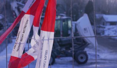 Ein Absperrband "Halt Polizei! Tatort nicht betreten!" hängt an einem Zaun um das Heizkraftwerk Lichterfelde.