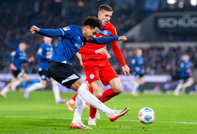 Monju Momuluh (Arminia Bielefeld, links) kommt hier zwar von Marko Ivezic (Holstein Kiel) zum Schuss, beschwört damit aber keine Gefahr herauf.