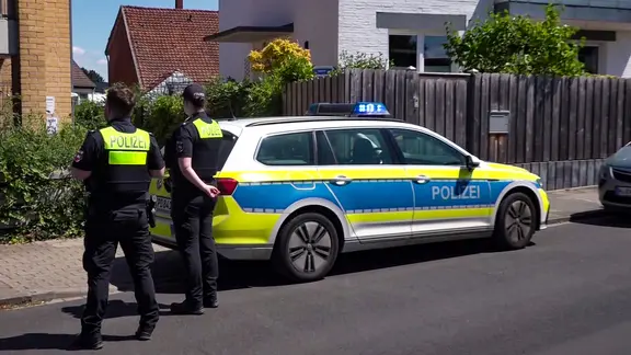 Arnum: Zwei Polizisten stehen vor einem Mehrfamilienhaus in der Gemeinde Hemmingen. | TeleNewsNetwork Arnum: Zwei Polizisten stehen vor einem Mehrfamilienhaus in der Gemeinde Hemmingen.