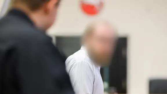Der Angeklagte steht im Gerichtssaal beim Mordprozess nach der Tötung einer jungen Frau. | Julian Stratenschulte/dpa Der Angeklagte steht im Gerichtssaal beim Mordprozess nach der Tötung einer jungen Frau.