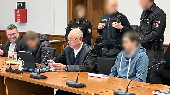 Zwei Männer sitzen mit ihren Verteidigern in einem Gerichtssaal. | NDR, Rafael Hein Zwei Männer sitzen mit ihren Verteidigern in einem Gerichtssaal.