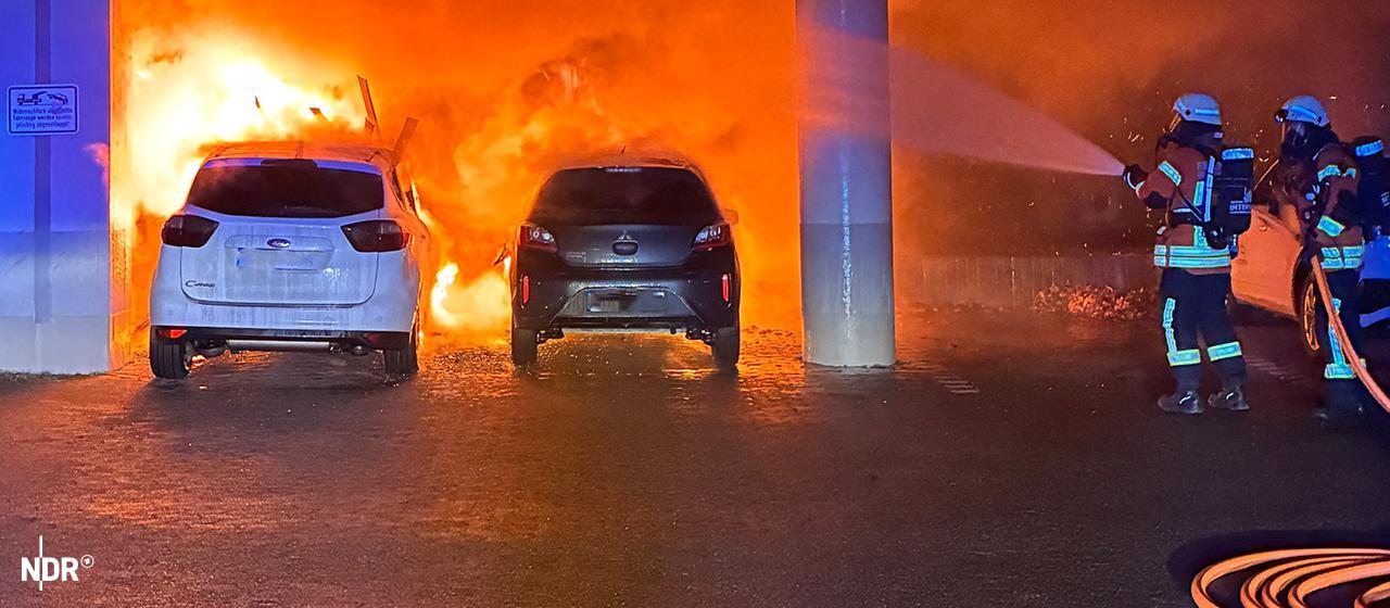 Zwei Feuerwehrleute löschen in Braunschweig zwei brennende Autos