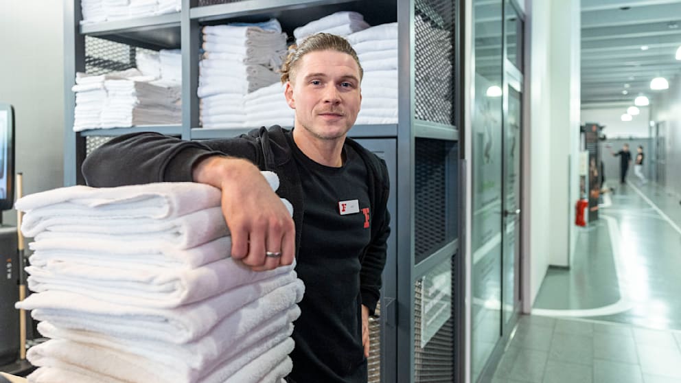 Bei „Fitness First” kann man kostenlos warm duschen. Max (31) verteilt Handtücher dazu