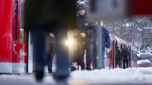 Fahrgäste warten in Reinbek auf die S-Bahn und steigen in einen eingefahrenen Zug. | dpa, Ulrich Perrey Fahrgäste warten in Reinbek auf die S-Bahn und steigen in einen eingefahrenen Zug.