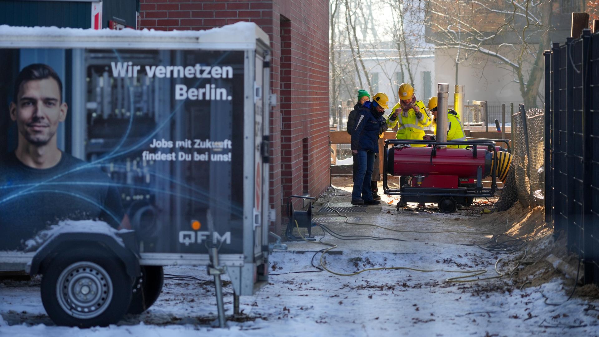 Mehrere Mitarbeiter des Umspannwerkes an der Argentinischen Allee stehen hinter einem Zaun nebeneinander. Im Vordergrund steht ein Anhänger mit der Aufschrift "Wir vernetzen Berlin". Mehrere Mitarbeiter des Umspannwerkes an der Argentinischen Allee stehen hinter einem Zaun nebeneinander. Im Vordergrund steht ein Anhänger mit der Aufschrift "Wir vernetzen Berlin".