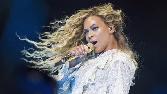 Beyoncé singt mit wehendem Haar und einem Mikro in der Hand.