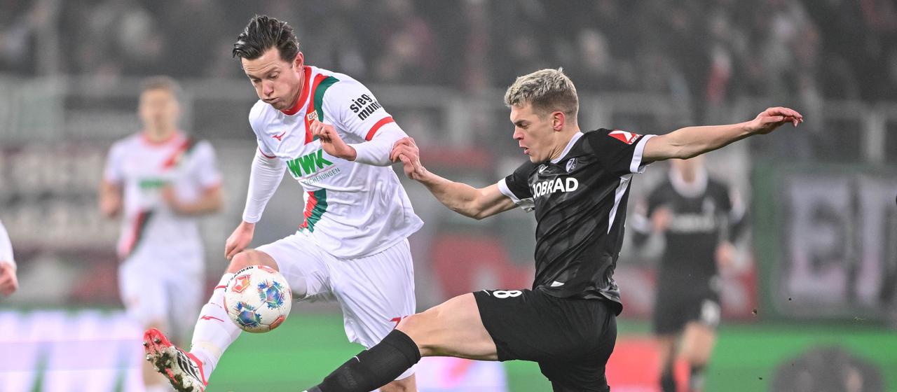 Augsburgs Michael Gregoritsch (l.) im Zweikampf mit Freiburgs Matthias Ginter | dpa Augsburgs Michael Gregoritsch (l.) im Zweikampf mit Freiburgs Matthias Ginter
