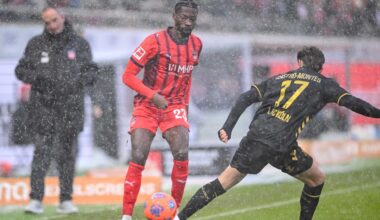 Im dichten Schneetreiben kämpfen beide Spieler um den Ball, der orangefarben ist, um besser erkannt zu werden.