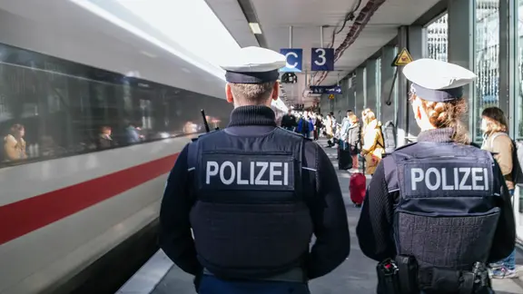 Zwei Einsatzkräfte der Bundespolizei laufen einen Bahnsteig am Hauptbahnhof in Hannover hinunter.