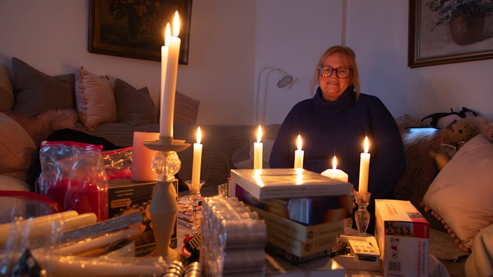 Monika hat alle Kerzen auf dem Wohnzimmertisch gesammelt