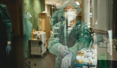 Ärzte vor Betreten der Covid-Station. Sie tragen Schutzkleidung und ziehen sich Handschuhe an.