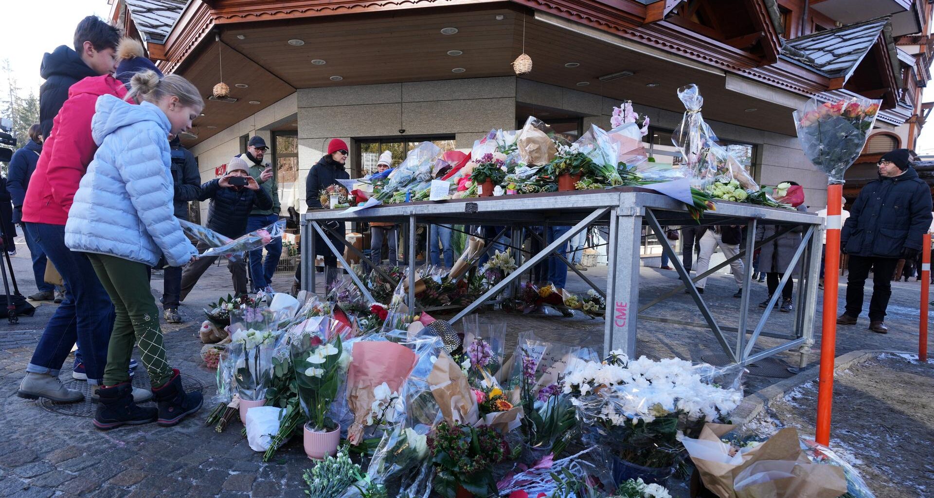 Menschen bringen Blumen und Briefe in die Nähe der abgeriegelten Bar, in der das Feuer ausgebrochen war.