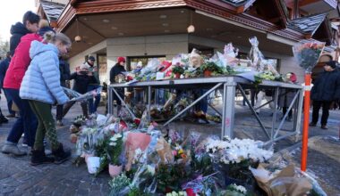 Menschen bringen Blumen und Briefe in die Nähe der abgeriegelten Bar, in der das Feuer ausgebrochen war.