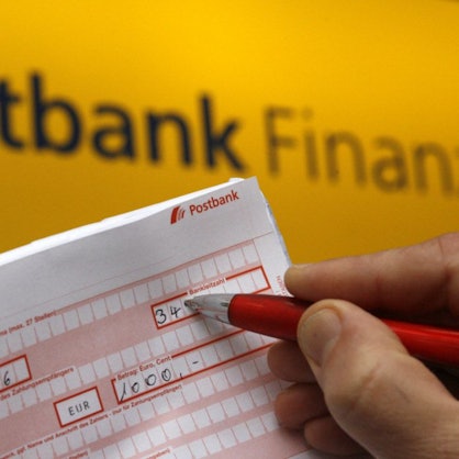 ILLUSTRATION - Ein Postbankkunde füllt  einen Überweisungsträger aus.