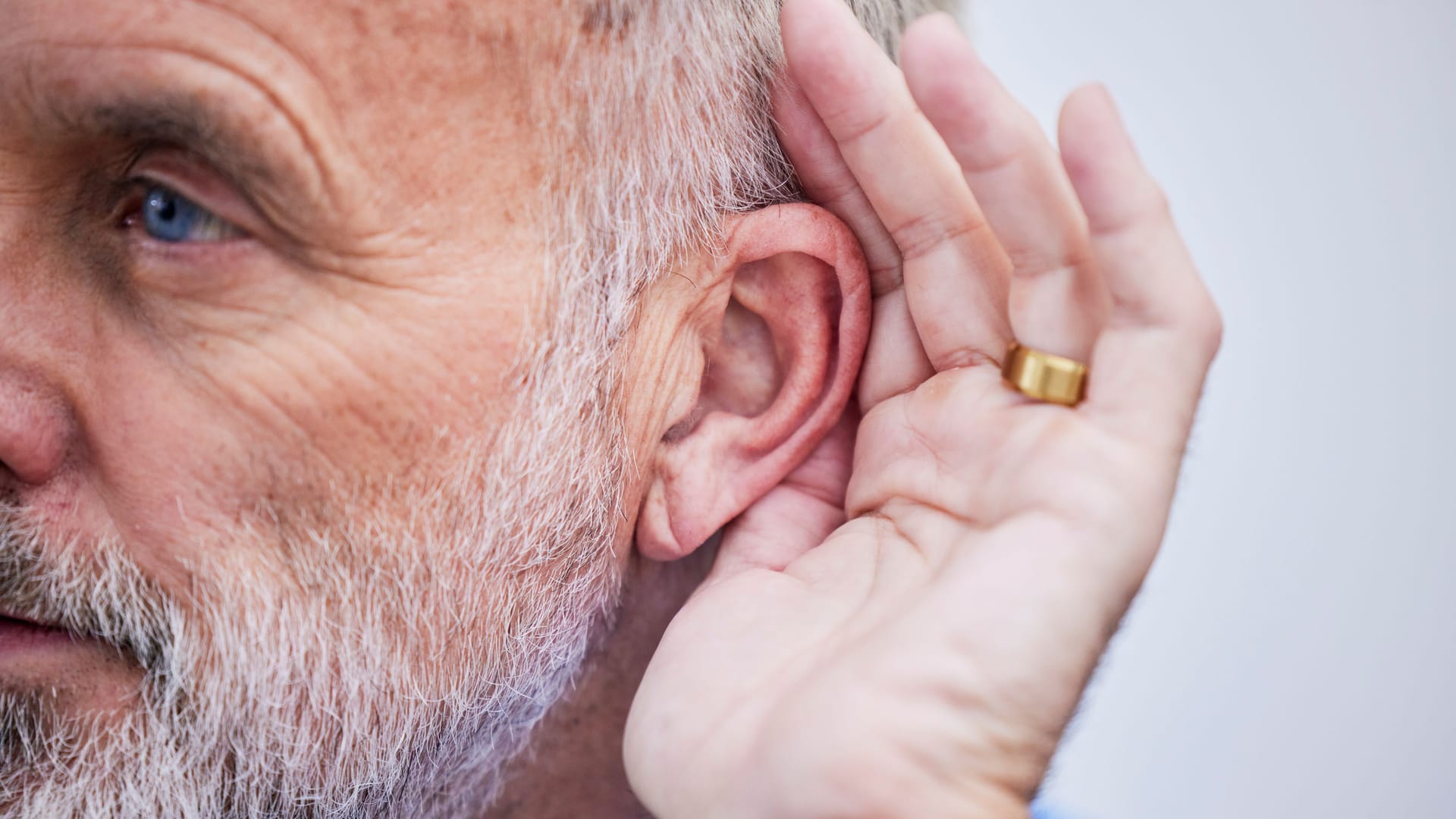 Ein Mann hält seine Hand ans Ohr Ein Mann hält seine Hand ans Ohr