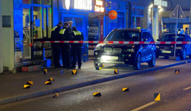 Polizisten und Blaulicht auf der nächtlichen Münsterstraße in Dortmund. Vor ihnen viele Hütchen, die Beweisspuren markieren.