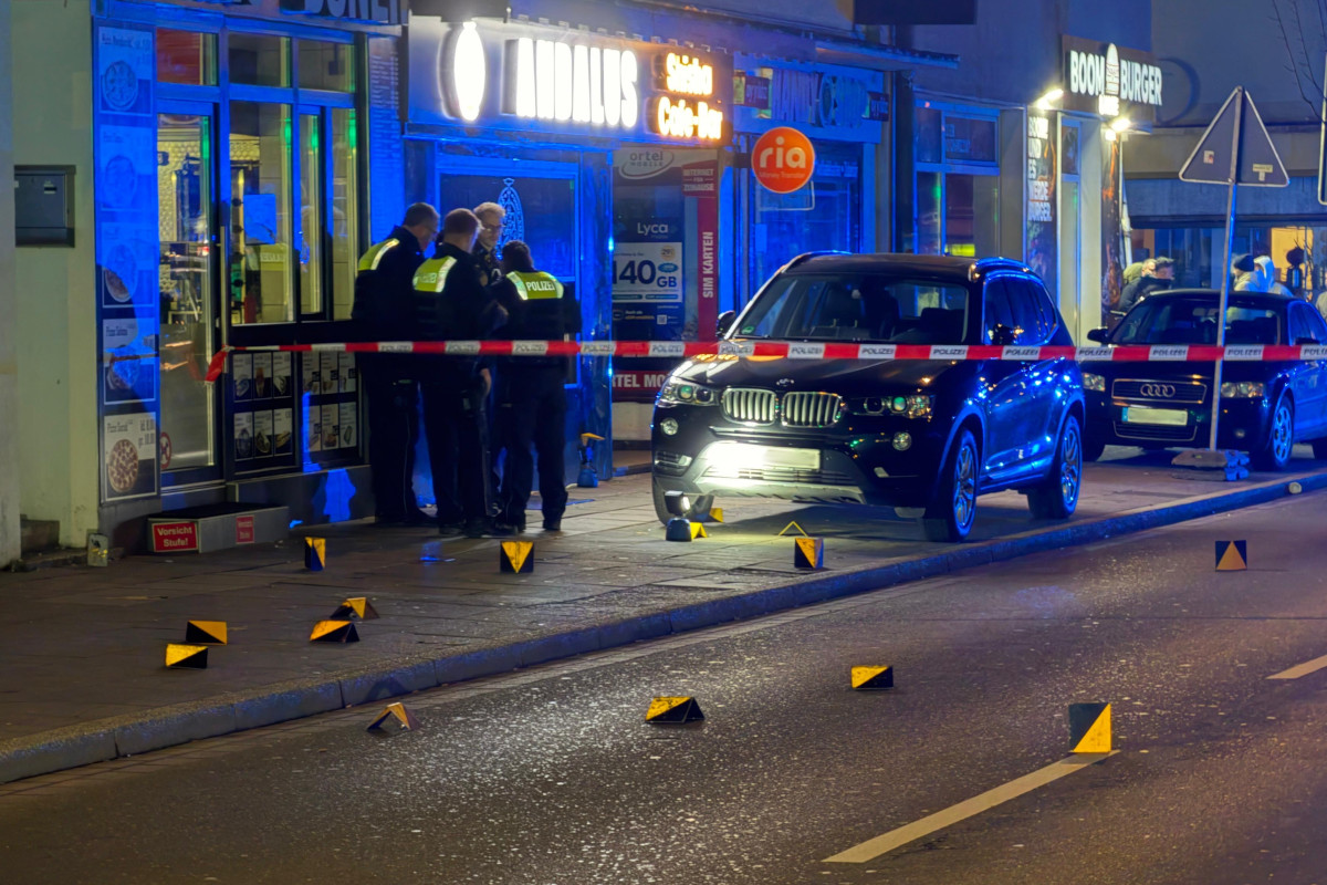 Polizisten und Blaulicht auf der nächtlichen Münsterstraße in Dortmund. Vor ihnen viele Hütchen, die Beweisspuren markieren.