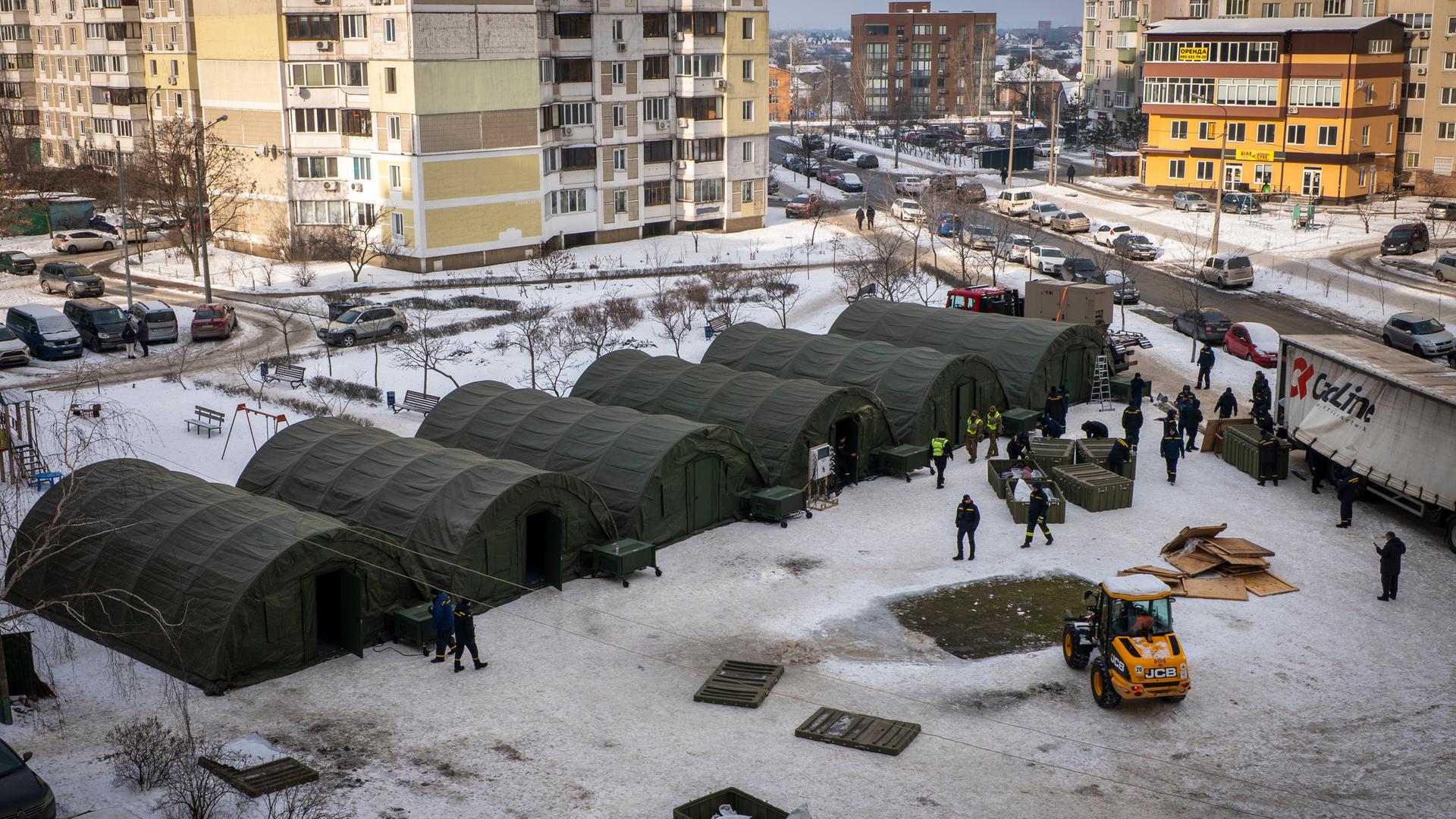 Kiew: Rettungskräfte stellen Zelte auf, in denen sich Bewohner benachbarter Wohnhäuser aufwärmen und nachts schlafen können.