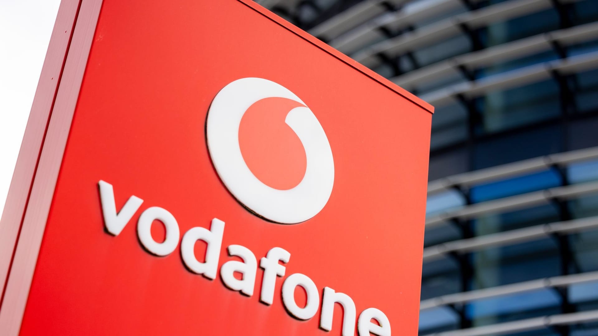 Firmenschild mit dem Logo von Vodafone steht vor Konzernzentrale