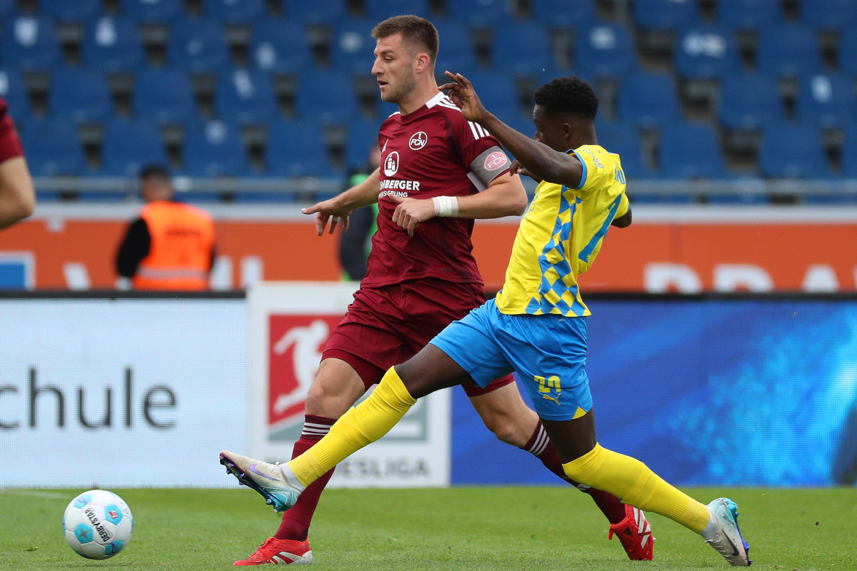 Robin Knoche im Nürnberg-Trikot im Laufduell mit Eintracht Braunschweigs Richmond Tachie.