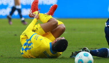 Dräger rollt nach einem Foulspiel über den Rasen.