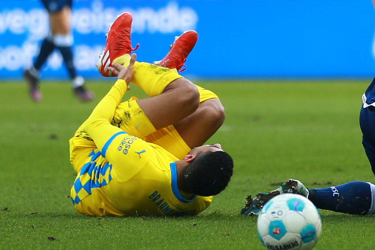 Dräger rollt nach einem Foulspiel über den Rasen.