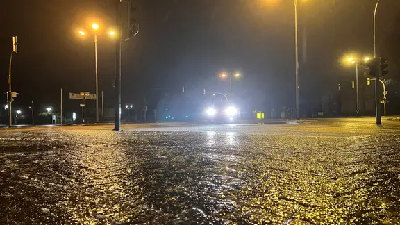 Auf einer Straße hat sich eine Eisschicht gebildet.