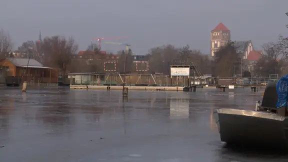 Auf der Warnow am Rostocker Mühlendamm hat sich eine ungleichmäßige Eisschicht gebildet. | Screenshot/NDR Auf der Warnow am Rostocker Mühlendamm hat sich eine ungleichmäßige Eisschicht gebildet.