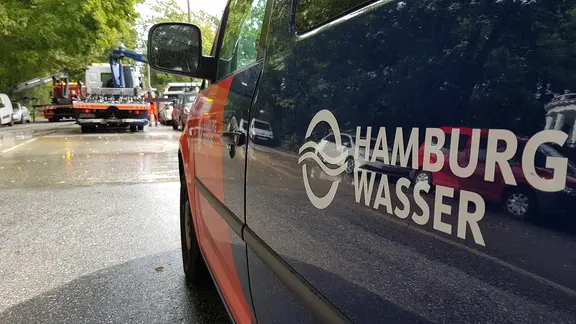 Ein Auto von Hamburg Wasser hält an einer von einem Wasserrohrbruch überspülten Straße. | NDR, Carl-Georg Salzwedel Ein Auto von Hamburg Wasser hält an einer von einem Wasserrohrbruch überspülten Straße.